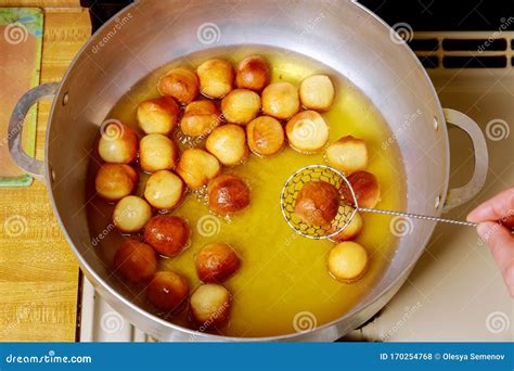 Buñuelos dorándose en aceite caliente en una sartén profunda