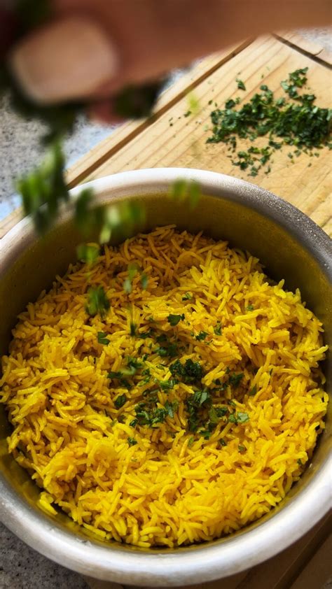 Plato de arroz con cúrcuma y ajo, decorado con perejil