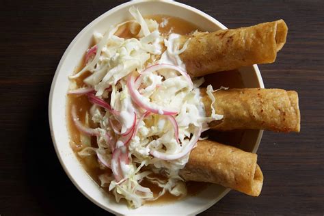 Tacos dorados ahogados en consomé rojo