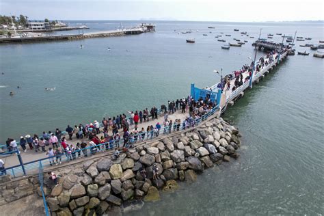 Imagen de pescadores cargando las andas de San Pedro hacia el muelle para iniciar la procesión.