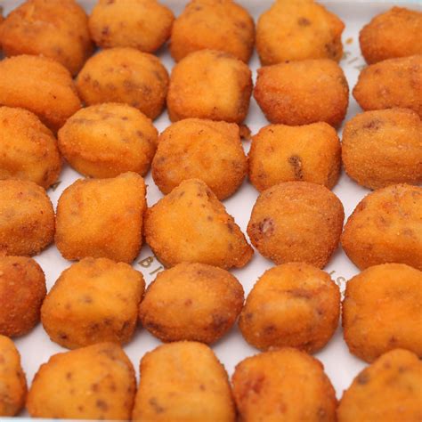 Foto detallada de una bandeja de croquetas caseras doradas y crujientes recién salidas de la freidora