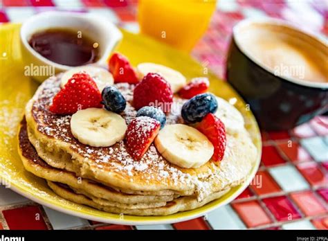 Tortitas con frutas y jarabe, mostrando una opción de desayuno dulce
