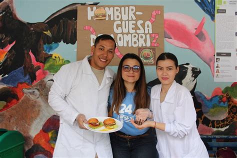 Estudiantes presentando su proyecto de hamburguesa de lombriz roja californiana en una feria científica.