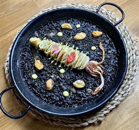 fotografía de un plato de arroz negro tradicional con calamares y gambas