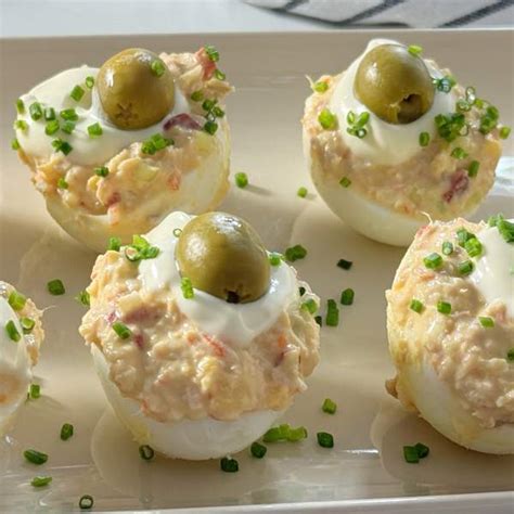 Foto de huevos rellenos de Navidad con decoración festiva de salmón y cebollino