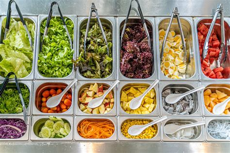 Foto de estudiantes probando ensaladas o participando en un Salad Bar