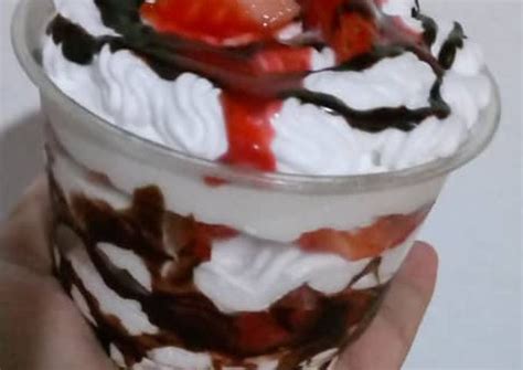 Copa de chocolate ya servida con helado, paleta de fresas con crema, moras azules y frambuesas.