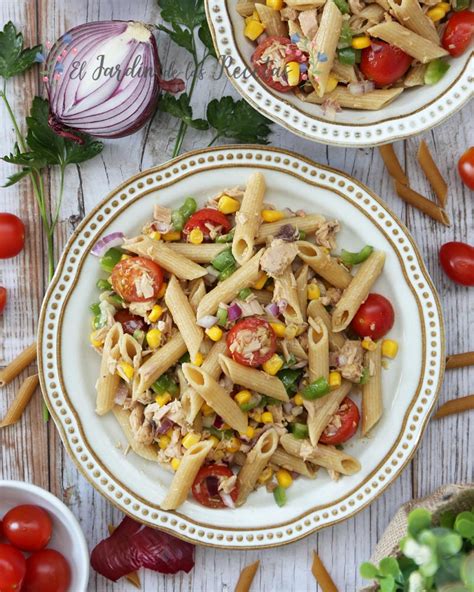 Plato de pasta recién servido con una rica salsa de atún, tomates frescos y un toque de albahaca fresca para decorar.