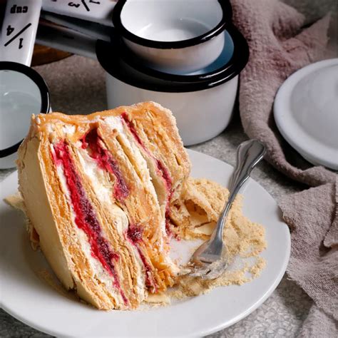 Plato de torta de frambuesa y manjar con capas visibles de crema y frutas