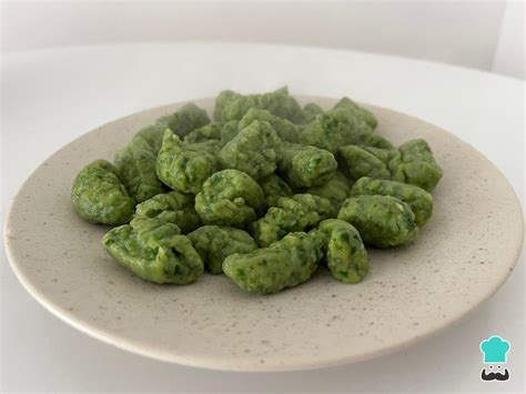 Recipiente hermético con ñoquis de espinaca crudos listos para congelar.