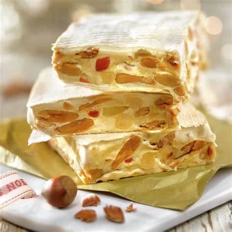 Primer plano de un trozo de turrón vegano casero decorado con frutos secos.