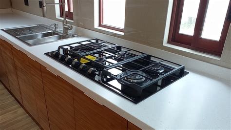 Una cocina moderna con una parrilla eléctrica sobre la encimera, mostrando su versatilidad para preparar diversos alimentos.