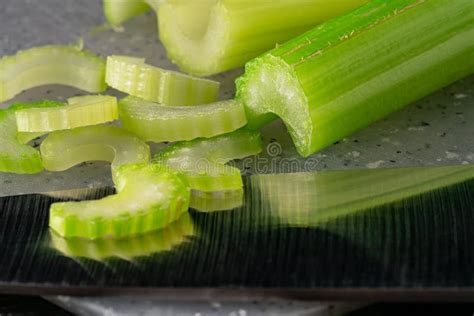 Tallos de apio fresco en una tabla de cortar, listos para jugo