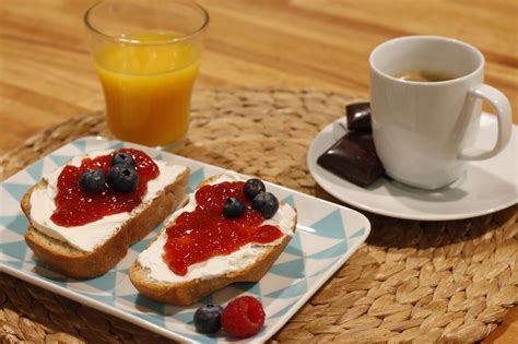 Fotografía de un desayuno saludable que incluye tostadas con mermelada de mora, yogur y fruta fresca
