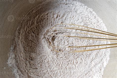 Ingredientes secos y líquidos para bizcocho vegano mezclándose en un bol.