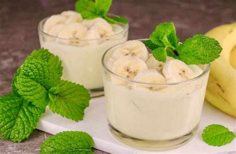 Mousse de plátano servida en copas individuales, decorada con rodajas de plátano y menta.