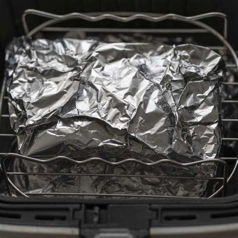 Costillas de cerdo horneándose lentamente envueltas en papel aluminio