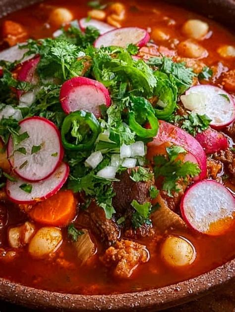Tazón de pozole rojo con guarniciones frescas