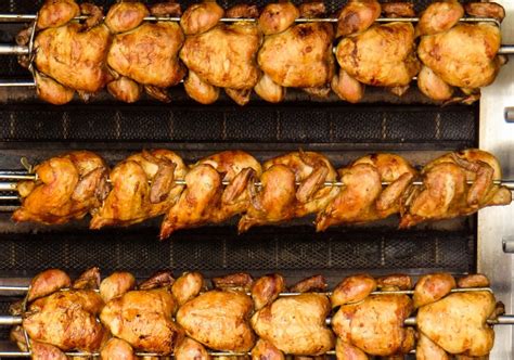Foto de pollos frescos listos para ser asados en un asador profesional