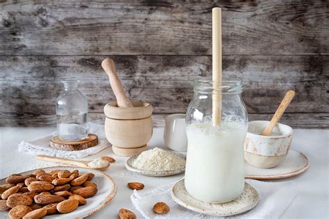 Persona añadiendo fermento en polvo a la leche vegetal en un recipiente no metálico
