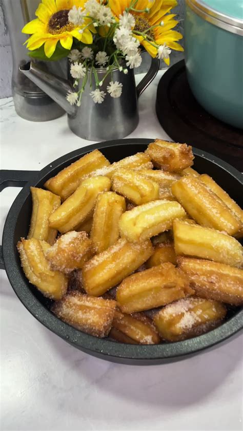 Churros dorados escurriéndose sobre papel de cocina