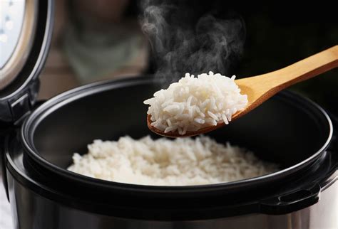 Arroz cocinándose en una olla con verduras coloridas.