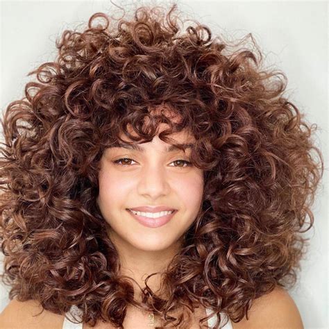 Mujer estilizando su cabello rizado con mousse