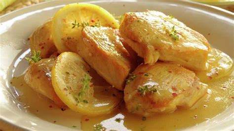 Plato servido de pollo con salsa de limón y alcaparras, acompañado de puré de brócoli