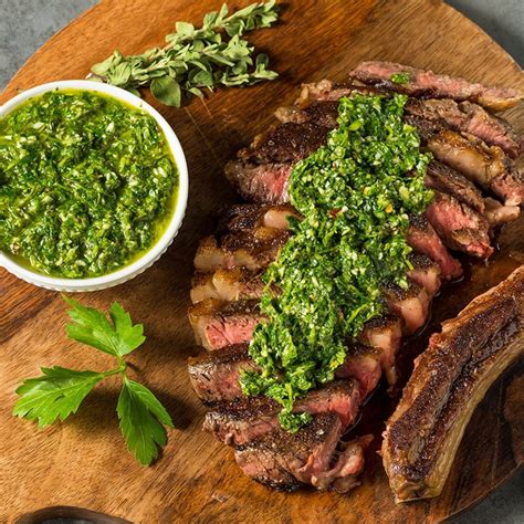 Fotografía de un asado argentino con chimichurri en un cuenco