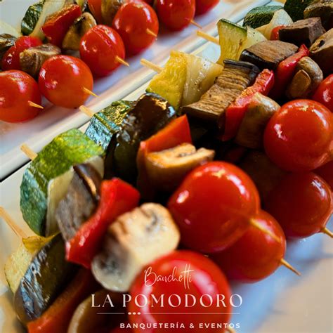 Brochetas vegetarianas coloridas con trozos de zapallo italiano, berenjena, cebolla, pimiento y champiñones.