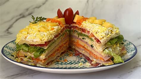 Una torta de panqueques con capas visibles, rellenos variados y una decoración rústica