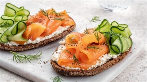 Foto apetitosa de un dip de salmón ahumado con tostadas y crudités, decorado con ciboulette y pimienta.