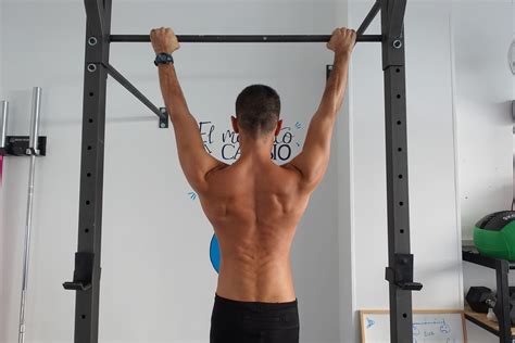 Hombre realizando dominadas en anillas como parte de un WOD de CrossFit