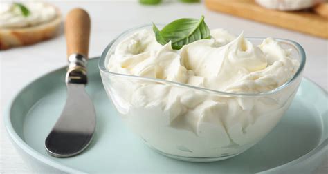 Queso crema en un bowl con espátula, mostrando su textura cremosa