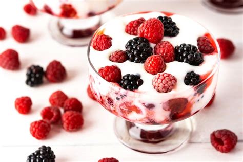 Copa cremosa de frutos rojos con capas de crema de queso y manjar, y chocolate blanco