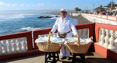 Vista de una playa chilena con quioscos vendiendo pan de huevo.