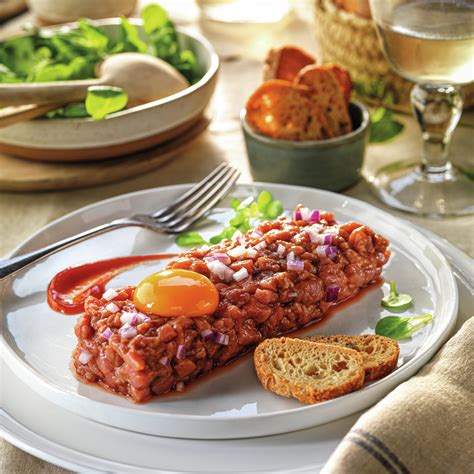 Plato de steak tartar con yema de huevo y tostadas