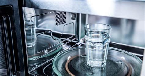 Microondas con vaso de agua y tortillas apiladas