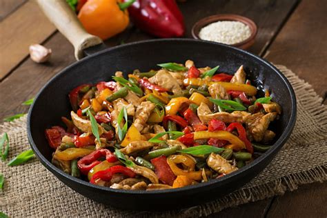 Wok con vegetales y pollo cocinándose en salsa de curry de coco