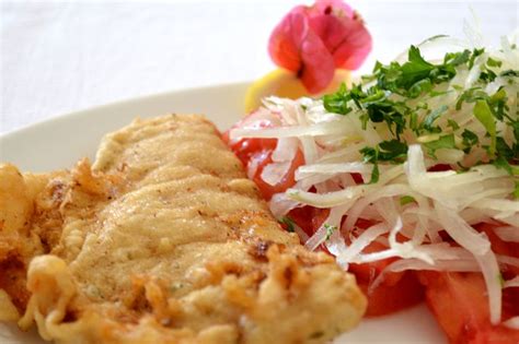 Plato de pescado frito chileno acompañado de ensalada chilena fresca