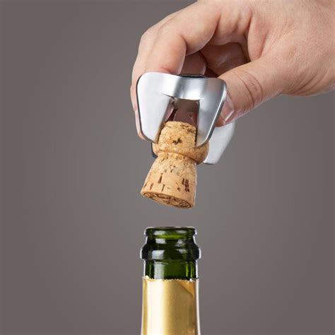 Fotografía de un abridor de champagne de cuatro puntas sobre una mesa elegante