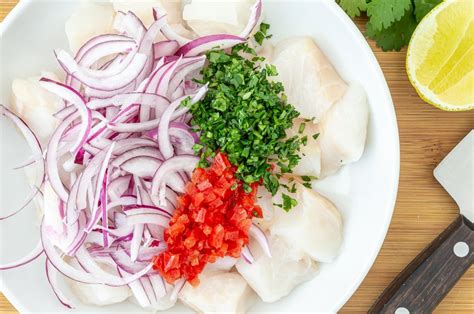 Ingredientes frescos para ceviche, incluyendo pescado, cebolla morada, cilantro y chiles