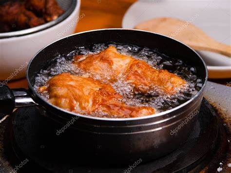 Proceso de freír flautas de pollo en aceite caliente