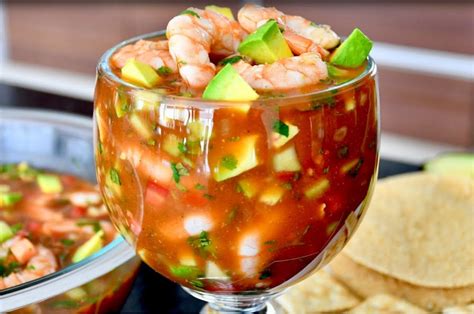 Plato de cóctel de camarones clásico presentado con aguacate y galletas saladas