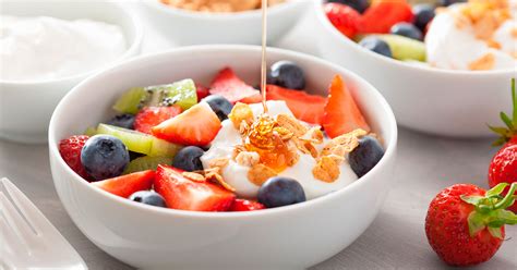 Primer plano de una colorida ensalada de frutas con yogur y frutos secos.