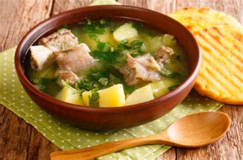 Tazón de caldo de costilla colombiano con papa y cilantro