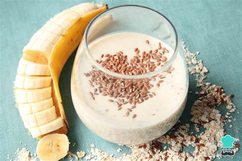 Imagen temática de un batido de plátano, avena y yogur servido en un vaso con toppings.