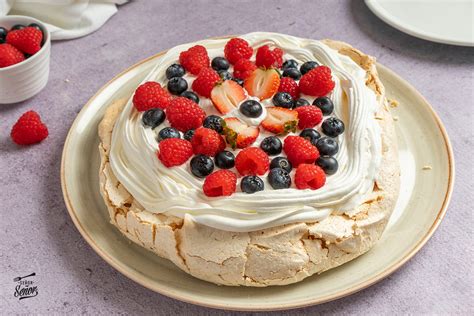Ilustración de una tarta Pavlova decorada con frutos rojos.