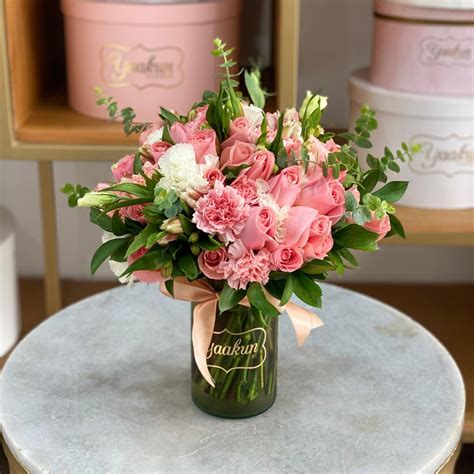Diseño floral moderno con diversas flores y follaje en un jarrón