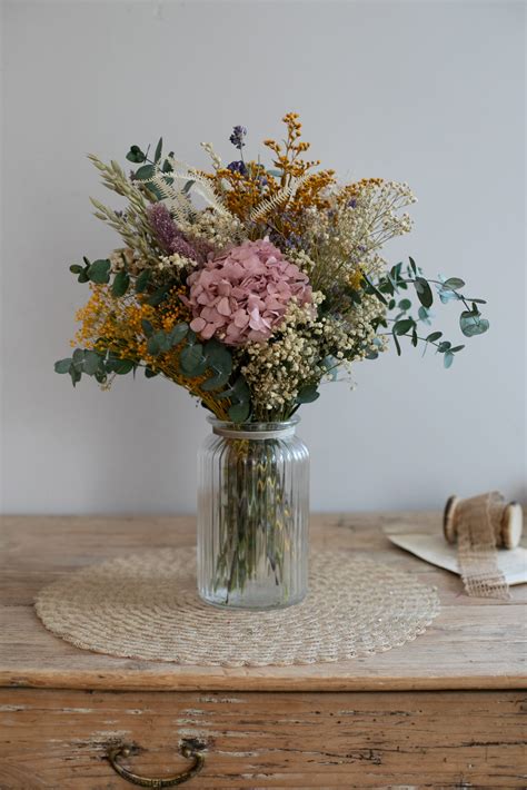 Ramo campestre con flores silvestres y hortensias en un jarrón de fibras naturales
